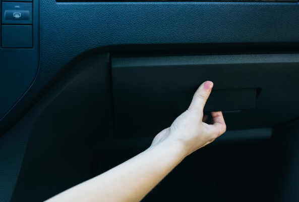 Junge Frau ist dabei das Handschuhfach zu öffnen als Symbolbild für den Ratgeber: Typenschein verloren