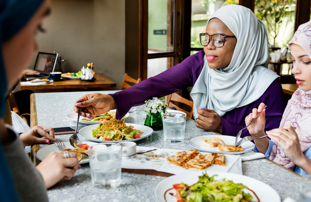 Islamische Freundinnen speisen gemeinsam als Symbolbild für den Ratgeber: Warum dürfen Muslime kein Schweinefleisch essen?