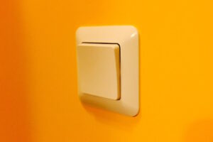 Vergilbter Lichtschalter auf orangener Wand als Symbolbild für den Ratgeber: Vergilbtes Plastik reinigen