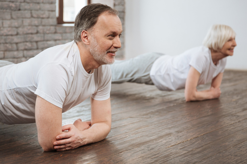 Älterer Mann und ältere Frau planken, um die Haltung zu verbessern