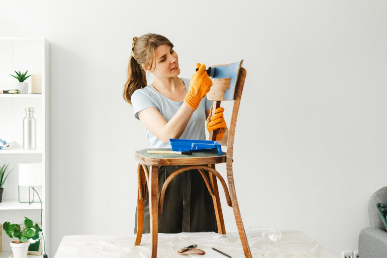 Eine junge Frau ist gerade dabei einen alten Stuhl upcyceln zu wollen