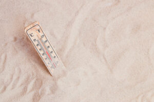 Ein Thermometer im Sand mit angenehmer Temperaturanzeige als Symbolbild für Ratgeber: Wo ist es im April warm