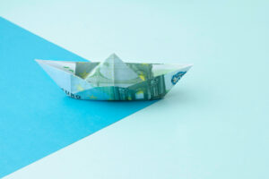 Origami aus einem 100 € Schein zu einem Schiffchen gefaltete als Symbolbild für den Beitrag: Wie viel Geld zur Konfirmation.