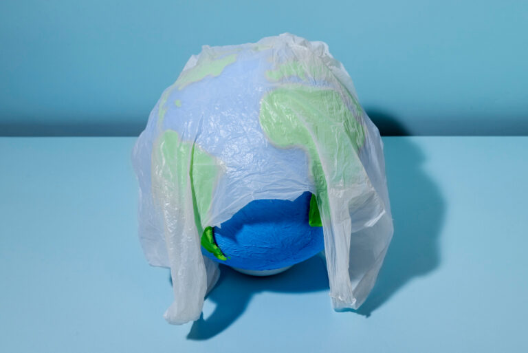 Die Erde eingehüllt in einer Plastiktüte als Symbolbild für den Ratgeber: Weniger Plastikmüll auf Reisen