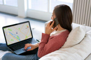 Junge Frau sitzt am Laptop und erstellt eine Routenplanung als Symbolbild für den Ratgeber: Google Maps Route erstellen