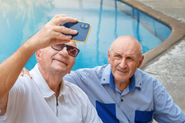 Alte Freunde, die gemeinsam ein Selfie machen, symbolisch für alte Freundschaften wieder aufleben lassen