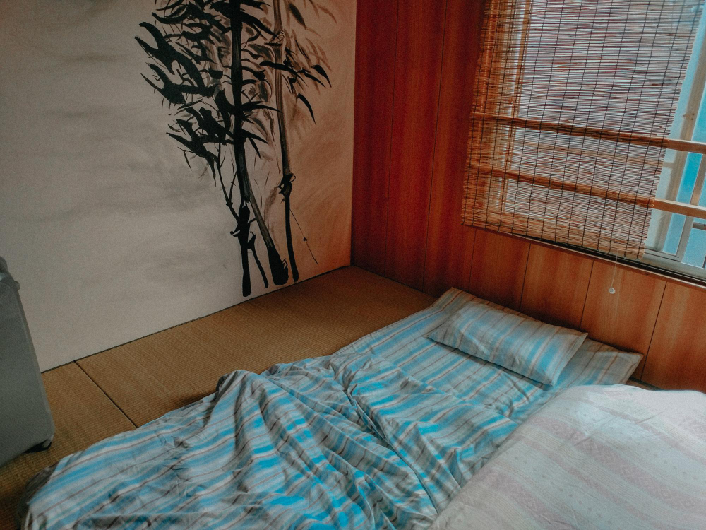 Ein Einblick in ein asiatisches Schlafzimmer mit Bett auf dem Boden als Symbolbild für Ratgeber: auf dem Boden schlafen