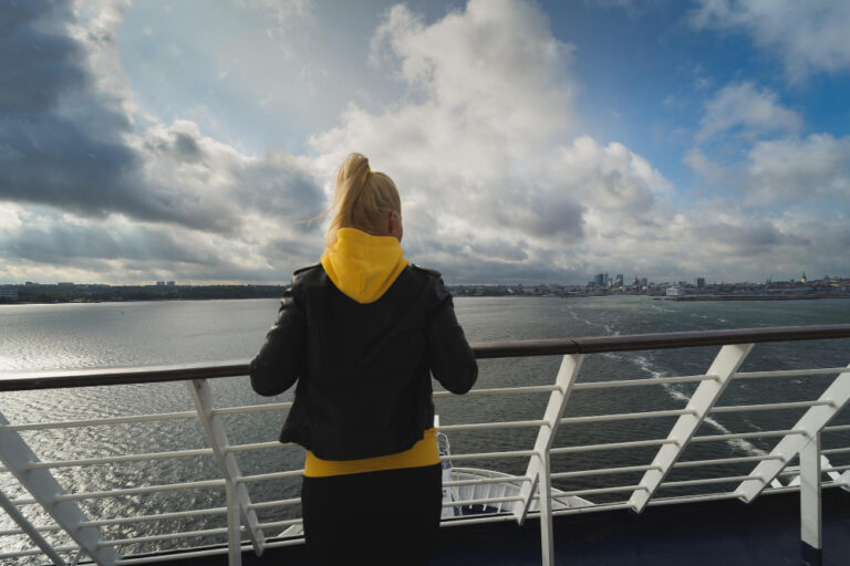 Junge Frau reist mit einem Frachtschiff als Symbolbild für Reisen ohne Flugzeug