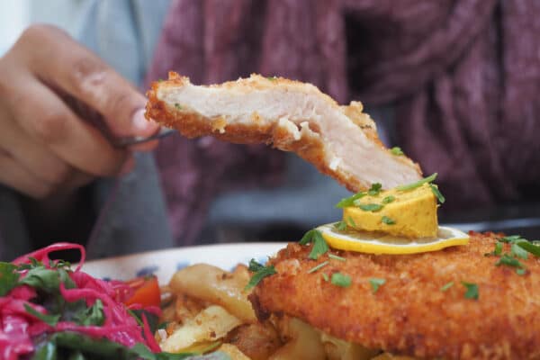 Ein Bisschen aufgeschnittenes Wiener Schnitzel als Symbolbild für den Beitrage: Schnitzel panieren