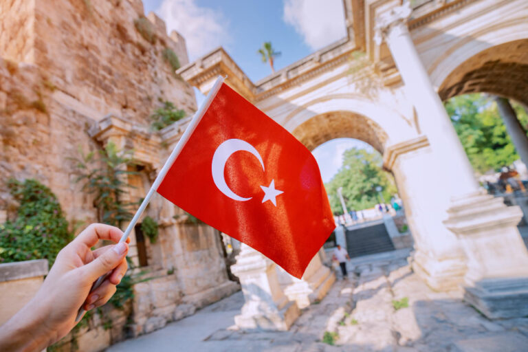 Türkische Flagge vor einem historischen Gebäude als Symbolbild für Ratgeber: Brauch ich einen Reisepass für die Türkei