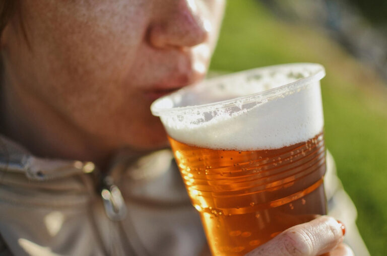Becher voll Bier am Mund - Symbolbild für den Ratgeber: Ist alkoholfreies Bier gesund?