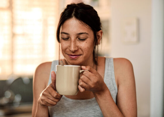 Junge Frau genießt ihren Kaffee als Symbolbild für den Ratgeber: Wirkt Koffein abführend?