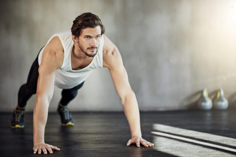 Man plankt mit ausgestreckten Armen als Symbolbild für den Ratgeber: Quadrobics als Fitnesstrend, was ist das?