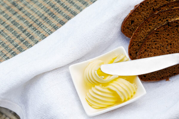 Eine Picknickdecke mit Einer Butterschale und Brot als Symbolbild für Ratgeber: Butter selber machen