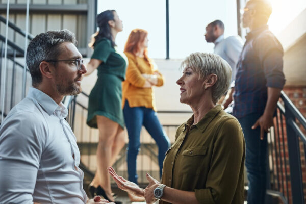 Introvertierte Person im Gespräch mit einer anderen auf einem Netzwerken-Event