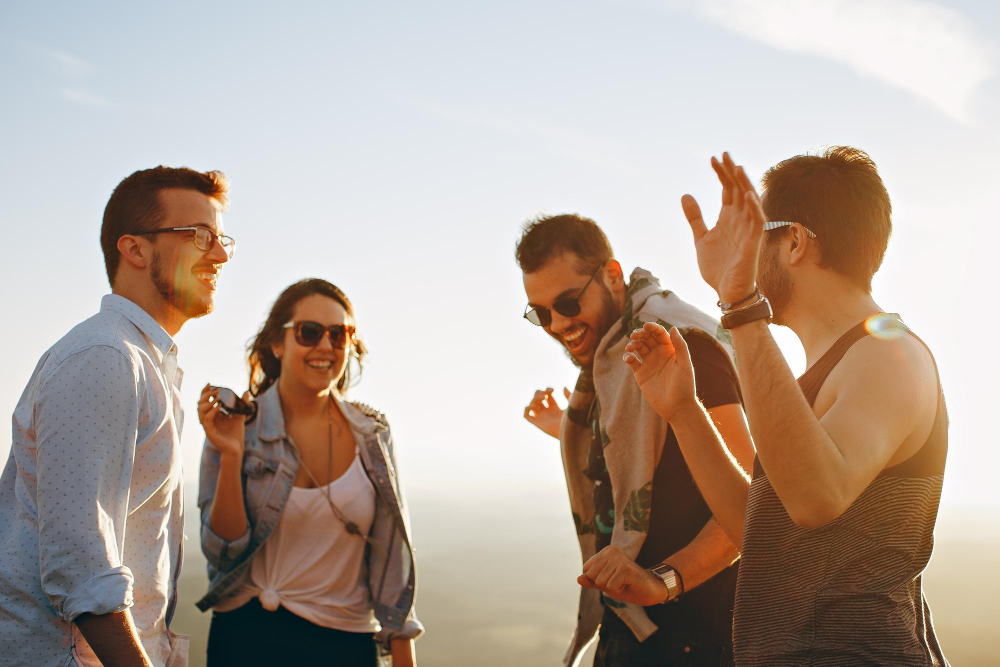 Vier Freunde versammelt an einem sonnigen Tag, symbolisch für wie Freundschaften unsere mentale Gesundheit beeinflussen