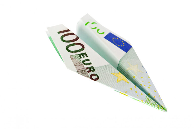 Papierflieger aus einem 100 € Schein als Symbolbild für den Ratgeber: Geld ins Ausland überweisen