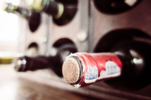 Flasche Wein im Weinregal als Symbolbild für den Ratgeber: Korken ohne Korkenzieher öffnen