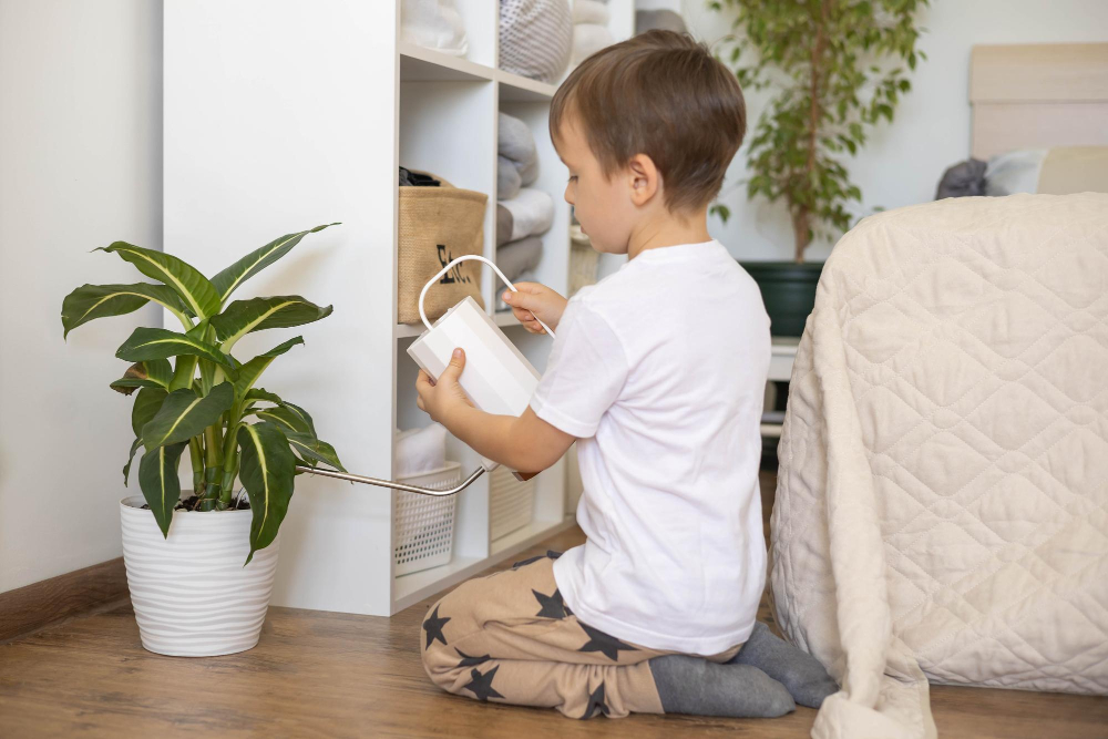 Junge gießt Zimmerpflanze als Symbolbild für den Ratgeber: Müssen Kinder im Haushalt helfen?