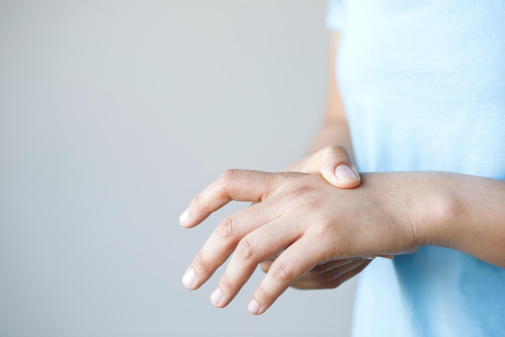 Frau hält sich die Hand als Symbolbild für den Ratgeber: Geht ein eingeklemmter Nerv von alleine weg?