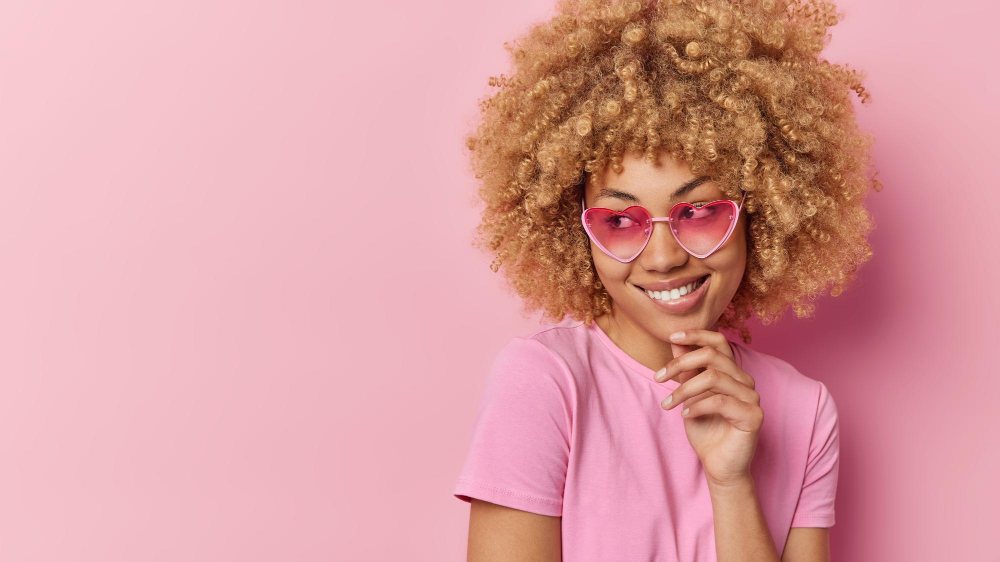 Frau blickt durch die rosane Brille als Symbolbild für den Beitrag: Was ist ein Crush?