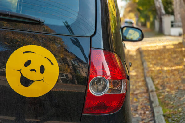 Smiley-Sticker auf dem Heck eines Autos als Symbolbild für den Ratgeber: Aufkleber vom Auto entfernen