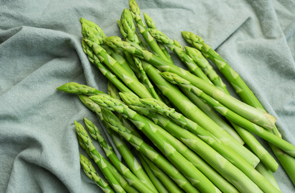 Viele Stangen grüner Spargel auf einem Tuch als Symbolbild für den Ratgeber: Wie viel Spargel pro Person?