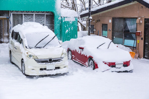 Schnee auf Autos und den Parkplätzen vor Wohnhäusern als Symbolbild für den Ratgeber: Beheizte Einfahrt