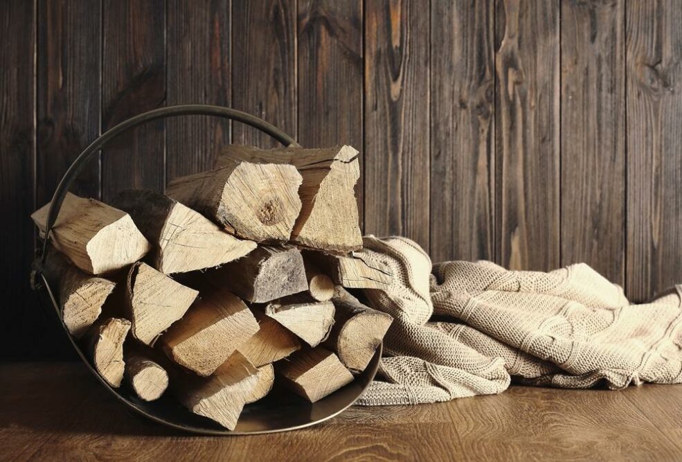 Brennholz lagern Ideen: Kaminholzstapel vor Holzwand mit Jutesack