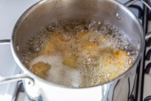 Ein Topf mit kochenden Kartoffeln, die schäumen