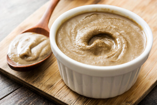 Eine kleine Keramikschüssel mit einer Creme als Symbolbild für Ratgeber: Was ist Tahini