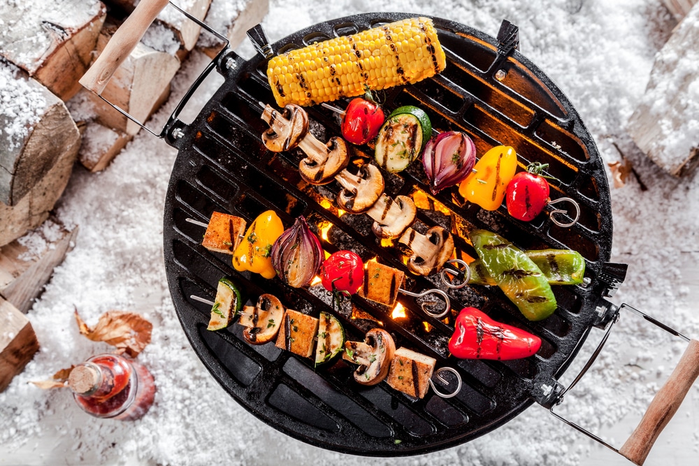 Grillgut auf einem kleinen Rundgrill aufgenommen von oben als Symbolbild für den Ratgeber: Wintergrillen