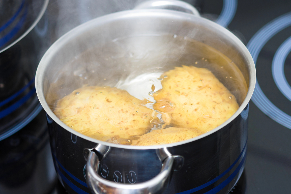 Kartoffeln im Topf voll Wasser auf dem Herd als Symbolbild für den Ratgeber: Wie lange müssen Kartoffeln kochen?