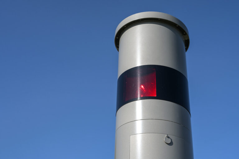 Teil einer stationären Geschwindigkeitsüberwachung mit Lichtradar, Rotlichtblitz und Kamera, Verkehrsüberwachung gegen gefährliche Geschwindigkeitsübertretungen, die ein Bußgeld oder Führerscheinentzug zur Folge haben können, blauer Himmel als Symbolbild für den Ratgeber: Wie viel Punkte darf man haben?