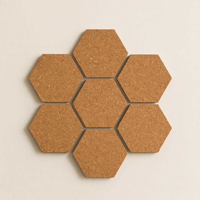 Sechseckige Kork-Pinnwandplatten in Wabenform an weißer Wand