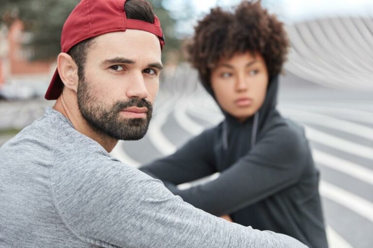 Junger Mann und junge Frau blicken ernst als Symbolbild für den Ratgeber: Mikroaggression einfach erklärt
