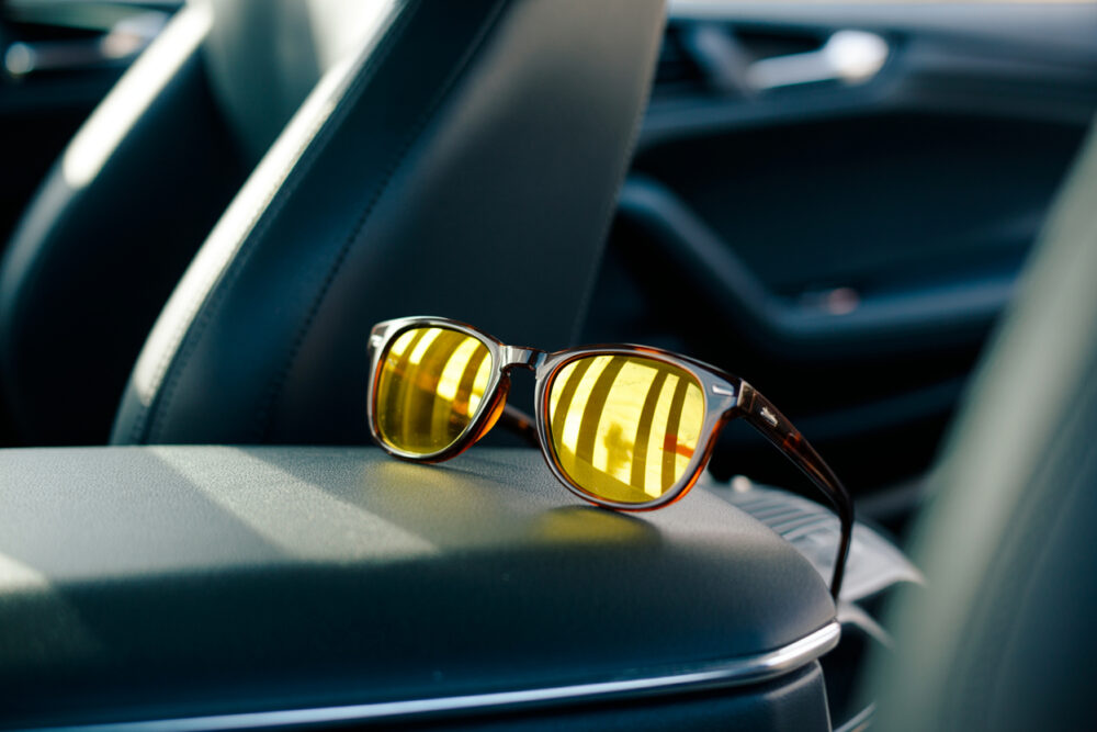 Nachtsichtbrille fürs Autofahren liegt auf der Mittelkonsole eines Autos.
