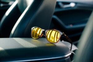 Nachtsichtbrille fürs Autofahren liegt auf der Mittelkonsole eines Autos.