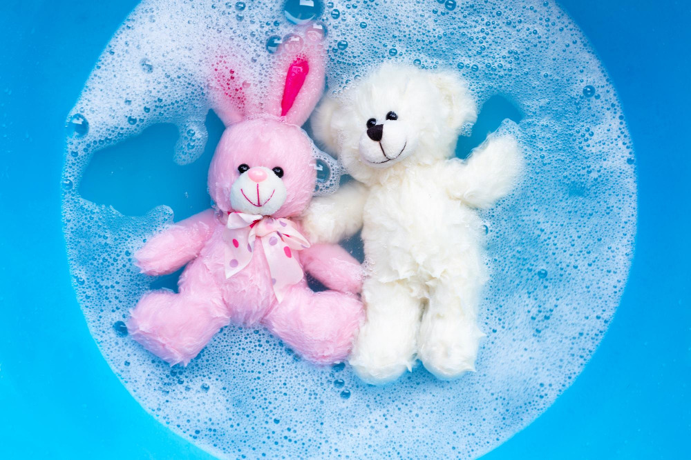 Ein rosafarbener Plüschhase und ein weißer Teddybär in einem Wasserbad