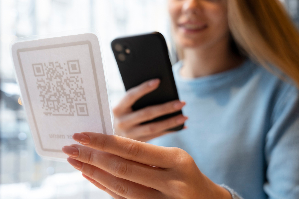 Frau scannt QR-Code mit Smartphone in einem Café.