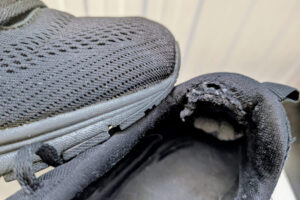 Schwarze Sneaker-Schuhe mit aufgeriebener kaputter Ferse