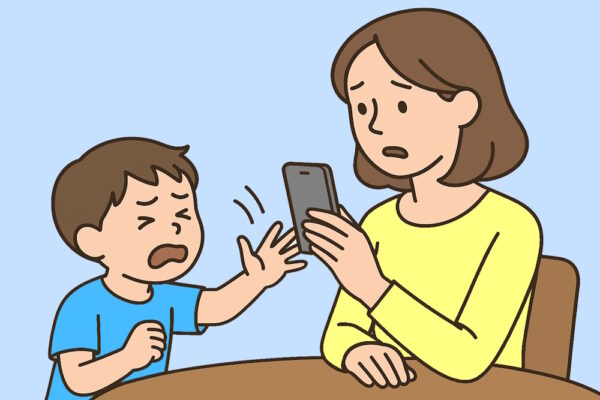 Quängelndes Kind versucht, seiner besorgten Mutter das Smartphone aus der Hand zu nehmen. (Illustration)