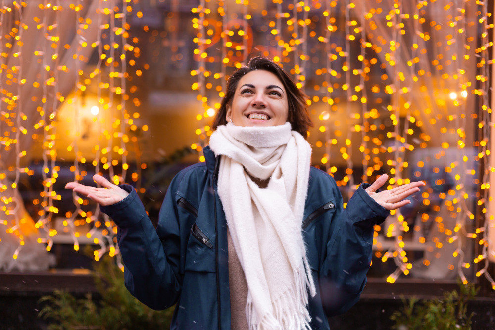 Frau in Winterjacke mit Schal genießt die Adventszeit