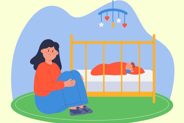 Mutter sitzt erschöpft neben Babybett, Baby schläft darin friedlich.