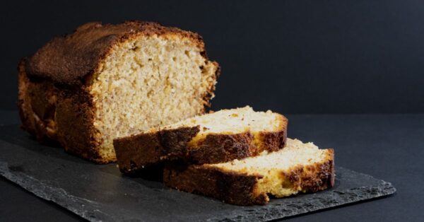 Aufgeschnittenes Bananenbrot in Scheiben auf dunkler Platte