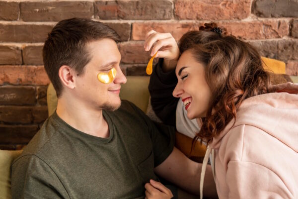 bester freund hat gefühle – zwei enge freunde sitzen nah beieinander, sie lächelt und berührt ihn sanft; moment zwischen freundschaft und liebe, unsicherheit und bedarf an ehrlichem gespraech