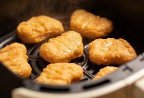 Chicken Nuggets in der Heißluftfritteuse: goldbraune Nuggets im Airfryer-Korb, knusprig gebacken und leicht dampfend.