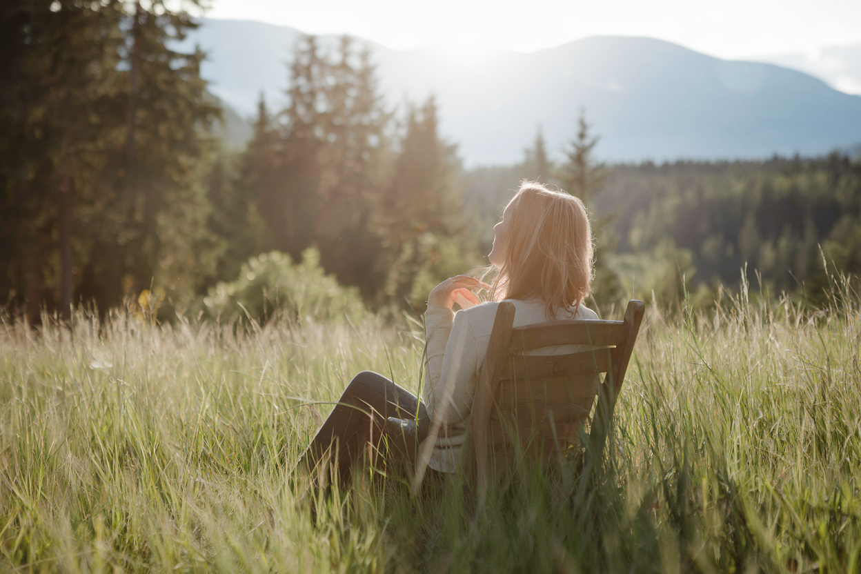 Frau entspannt in der Natur, symbolisch für Offline Tage genießen.