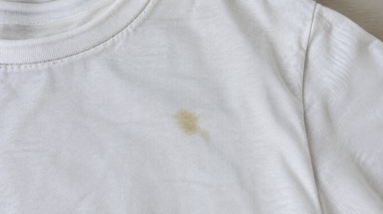 Kleiner Fettfleck auf einem hellen Shirt nach dem Waschen