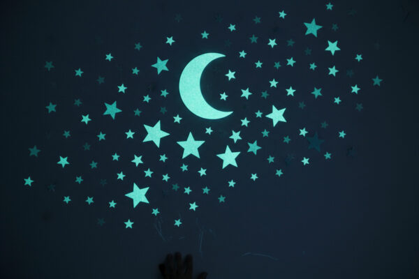 Phosphoreszierende Glow-in-the-Dark Sterne und Mond an der Wand - anschauliches Beispiel für fluoreszierende Farbe vs. phosphoreszierend im Dunkeln.